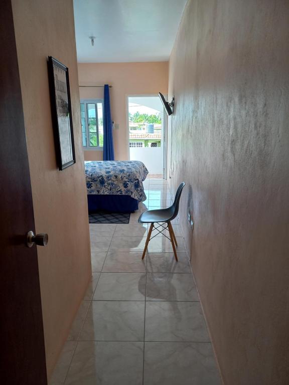 Entrance hallway view into bedroom with modern chair